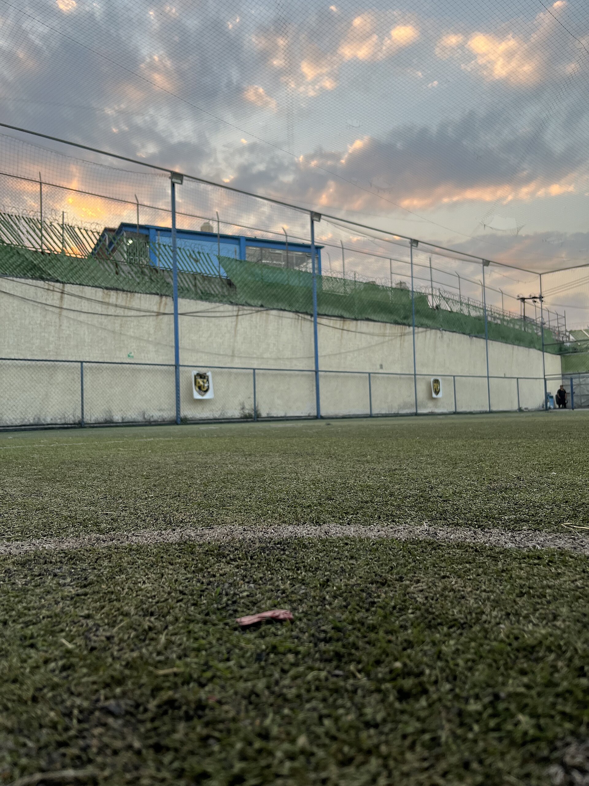 Cancha de fútbol 7 al atardecer con malla alrededor